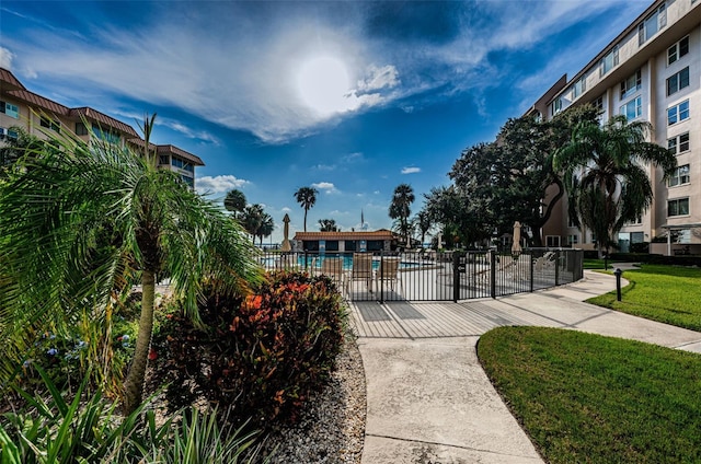 surrounding community featuring a swimming pool, a lawn, and a patio