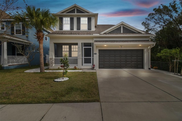 view of front facade with a porch, a yard, and a garage