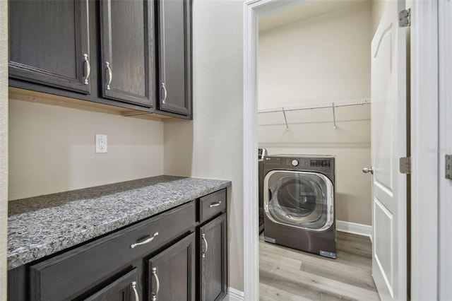 laundry area with washer / clothes dryer and light hardwood / wood-style flooring