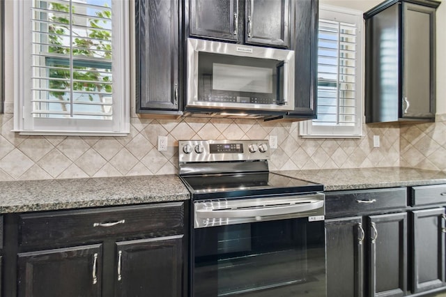 kitchen with stainless steel appliances, decorative backsplash, and light stone countertops