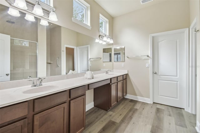 bathroom with a shower with door, vanity, and hardwood / wood-style floors