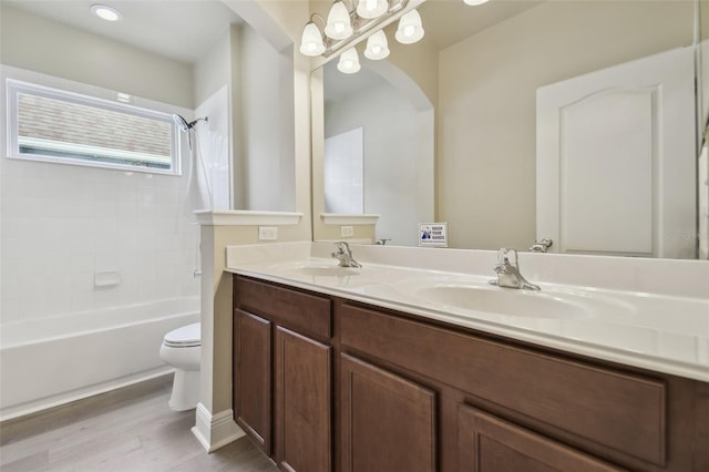 full bathroom with toilet, wood-type flooring, shower / washtub combination, and vanity