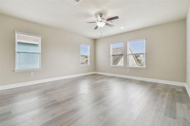 empty room with ceiling fan, light hardwood / wood-style flooring, and a wealth of natural light