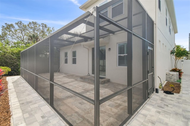 view of property exterior featuring a lanai and a patio