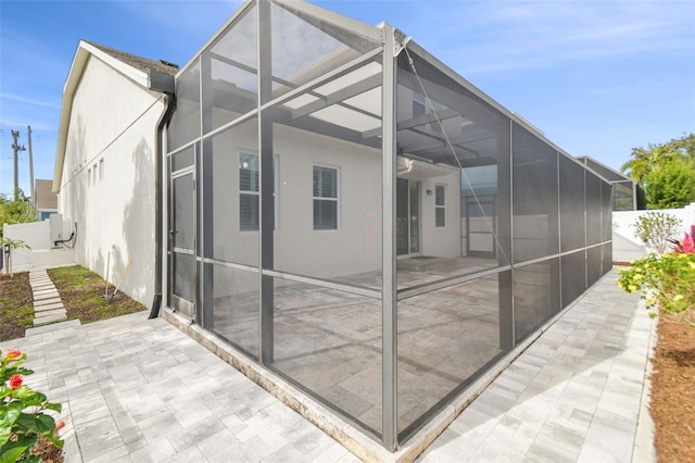 rear view of house with a lanai and a patio