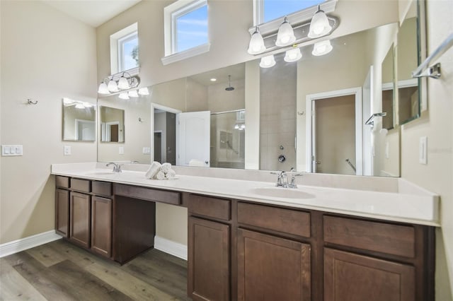 bathroom with a sink, wood finished floors, a high ceiling, and a stall shower