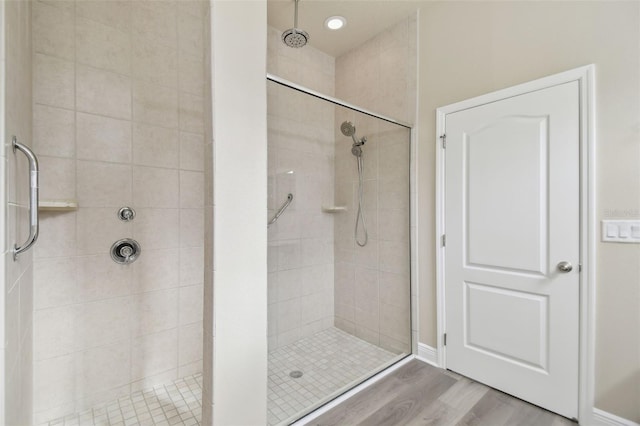 bathroom with a stall shower and wood finished floors