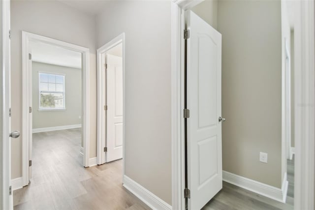 hall featuring baseboards and light wood-style floors