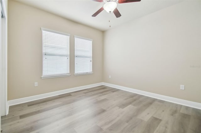 empty room featuring light wood-style flooring, a ceiling fan, and baseboards