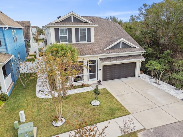 view of front facade featuring fence, roof with shingles, an attached garage, a front lawn, and concrete driveway