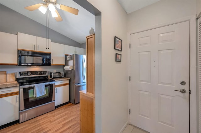 kitchen featuring lofted ceiling, light wood-type flooring, white cabinets, appliances with stainless steel finishes, and ceiling fan