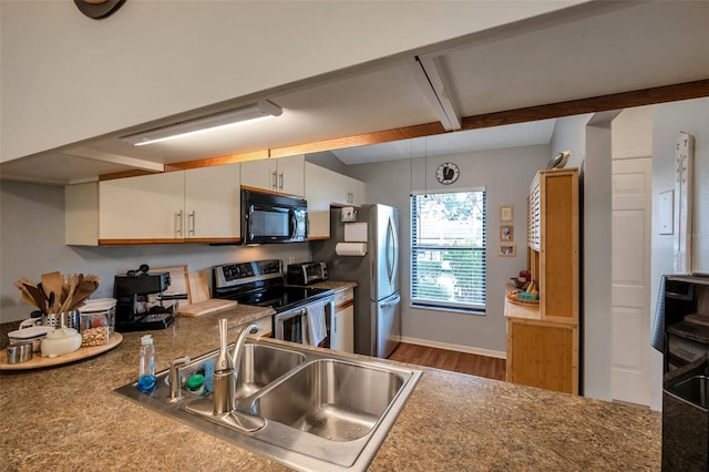 kitchen featuring wood-type flooring, stainless steel appliances, hanging light fixtures, sink, and white cabinetry