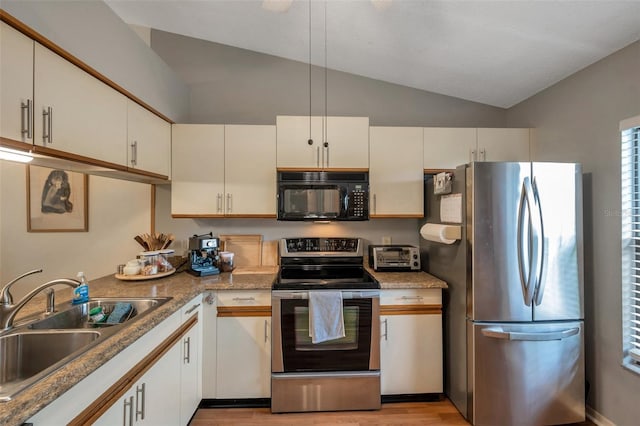 kitchen featuring vaulted ceiling, appliances with stainless steel finishes, white cabinets, light hardwood / wood-style flooring, and sink