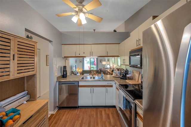 kitchen with stainless steel appliances, sink, white cabinetry, ceiling fan, and light wood-type flooring