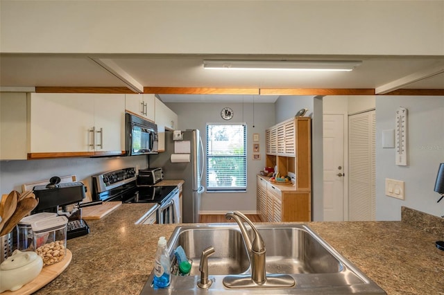 kitchen featuring stainless steel appliances, white cabinets, and sink