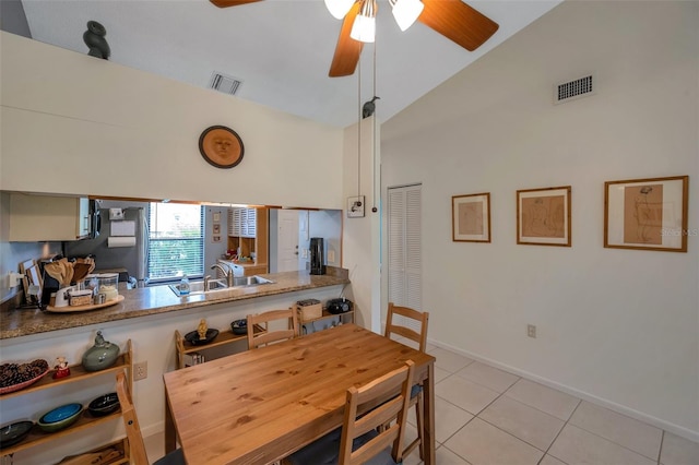 dining area with lofted ceiling, ceiling fan, light tile patterned floors, and sink