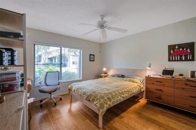 bedroom featuring a textured ceiling, ceiling fan, and hardwood / wood-style flooring