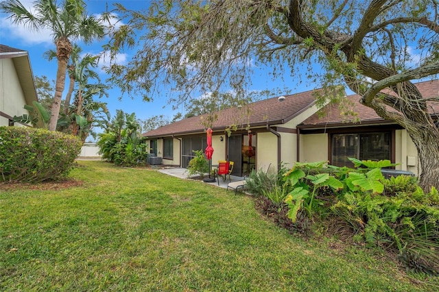 rear view of property featuring a yard and central AC unit