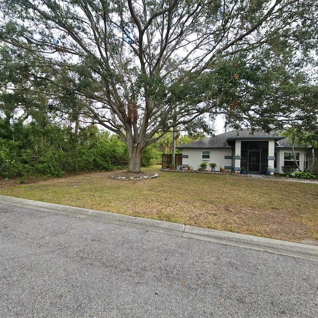 view of front of home with a sunroom and a front yard