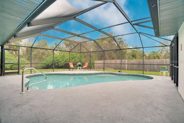 view of pool featuring glass enclosure, a patio, fence, and a fenced in pool