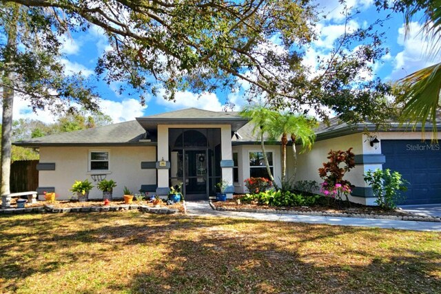 ranch-style house featuring stucco siding, an attached garage, and a front yard