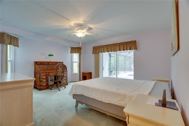 bedroom with ceiling fan, light carpet, a textured ceiling, and access to exterior