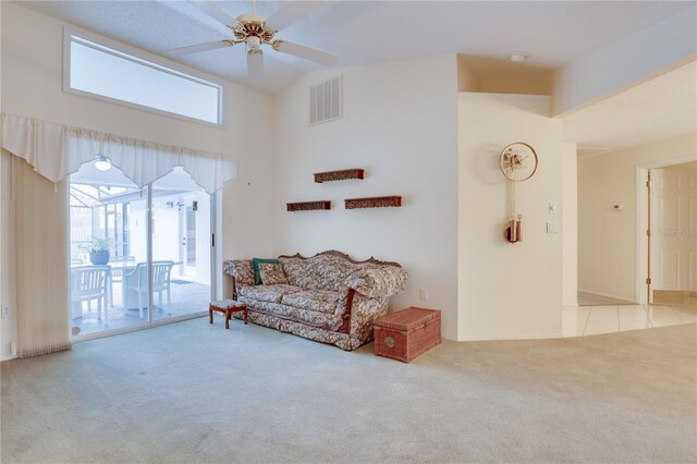 living area with vaulted ceiling, carpet, visible vents, and ceiling fan