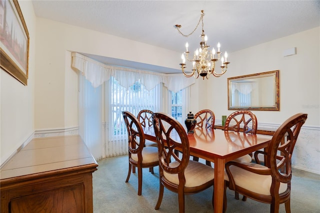 dining space with a notable chandelier and light colored carpet