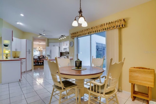 dining room with light tile patterned floors and ceiling fan with notable chandelier