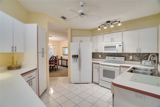 kitchen with white appliances, visible vents, a sink, light countertops, and tasteful backsplash