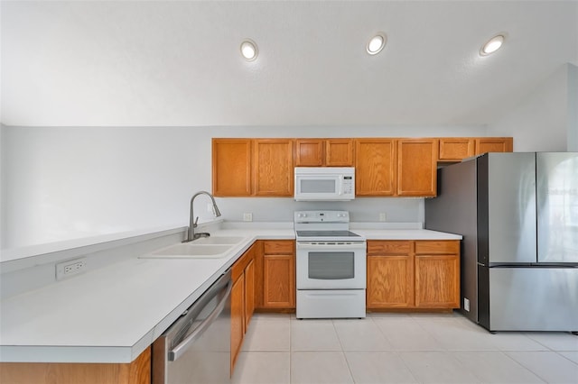 kitchen with appliances with stainless steel finishes, sink, and light tile patterned floors