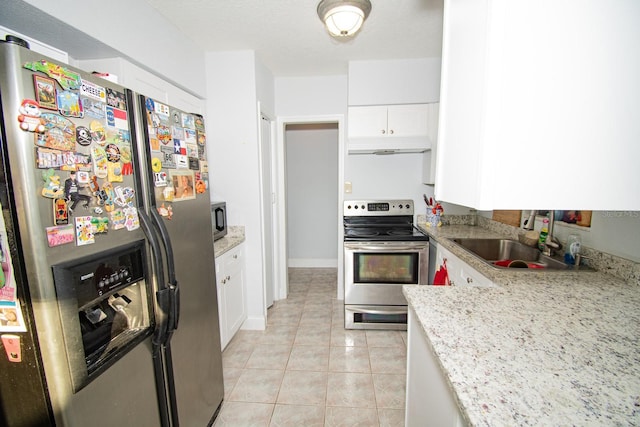 kitchen featuring light stone counters, stainless steel appliances, light tile patterned floors, white cabinets, and sink