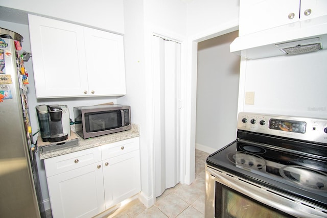 kitchen featuring stainless steel appliances, light tile patterned flooring, and white cabinetry