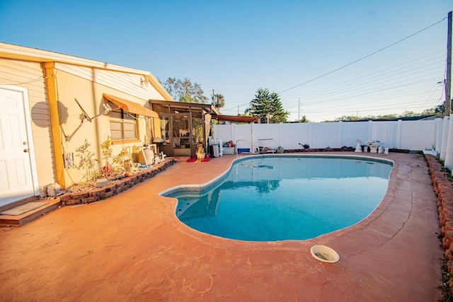 view of swimming pool with a patio area and a sunroom