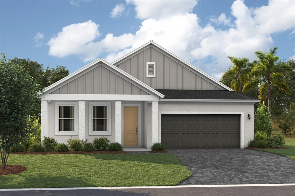 view of front of home with a garage and a front lawn