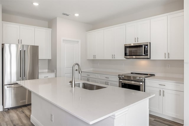 kitchen with a kitchen island with sink, a sink, visible vents, appliances with stainless steel finishes, and light wood-type flooring