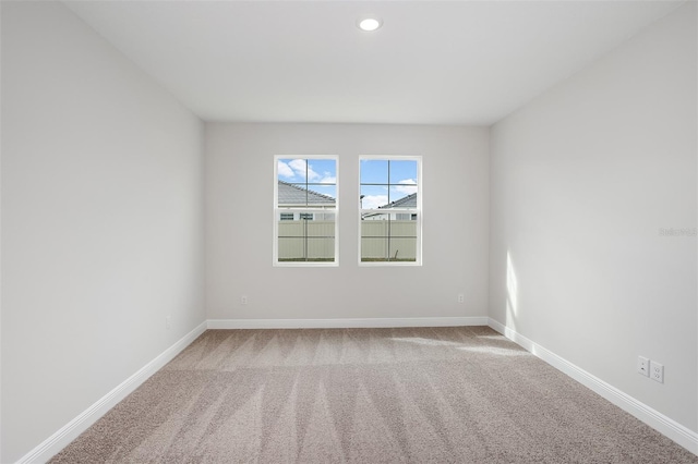 spare room with recessed lighting, carpet, and baseboards