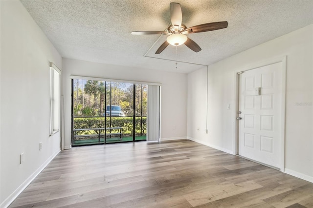 spare room with a textured ceiling, ceiling fan, and light hardwood / wood-style floors