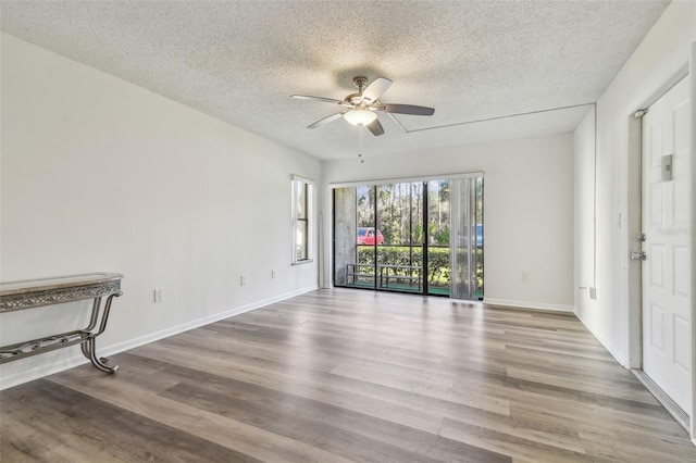 spare room featuring hardwood / wood-style flooring, a textured ceiling, and ceiling fan