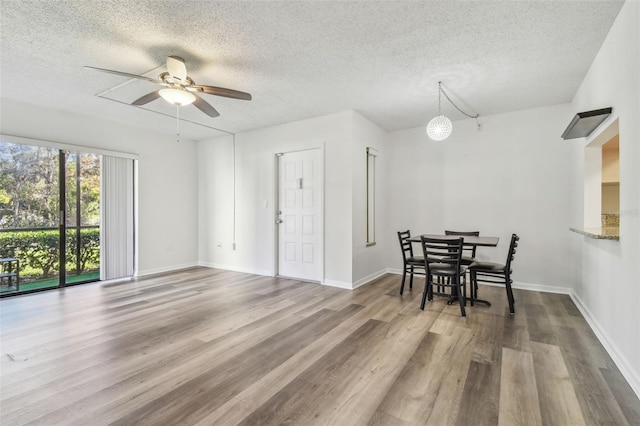 dining area featuring ceiling fan, hardwood / wood-style floors, and a textured ceiling