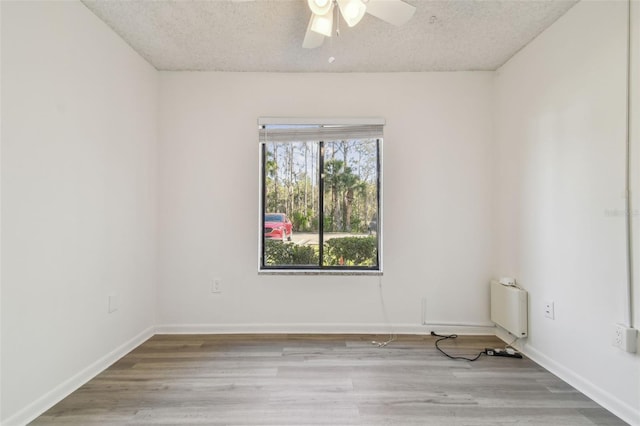 unfurnished room featuring a textured ceiling, ceiling fan, and light hardwood / wood-style flooring