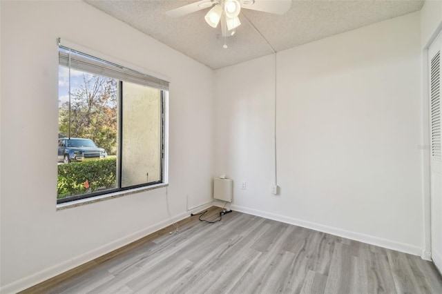 spare room with a textured ceiling, ceiling fan, and a healthy amount of sunlight