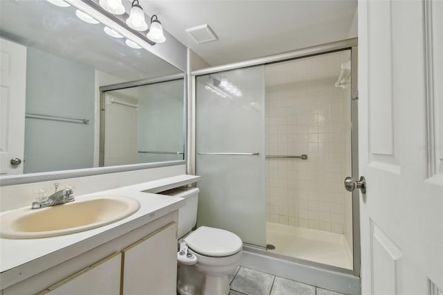 bathroom featuring toilet, tile patterned flooring, a shower with door, and vanity