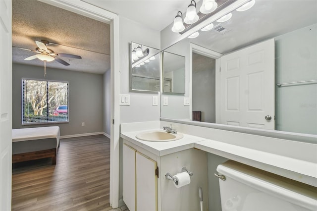 bathroom featuring toilet, a textured ceiling, ceiling fan, wood-type flooring, and vanity