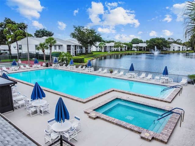 view of swimming pool with a community hot tub, a patio, and a water view