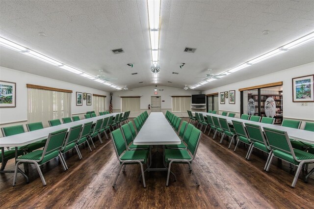 dining space with lofted ceiling, a textured ceiling, ceiling fan, and dark hardwood / wood-style floors