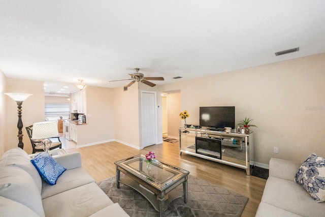 living room featuring hardwood / wood-style floors and ceiling fan