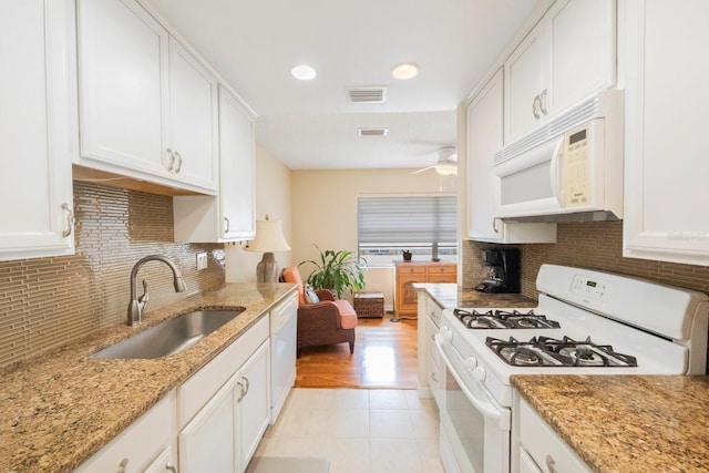 kitchen featuring white cabinetry, sink, ceiling fan, light stone counters, and white appliances