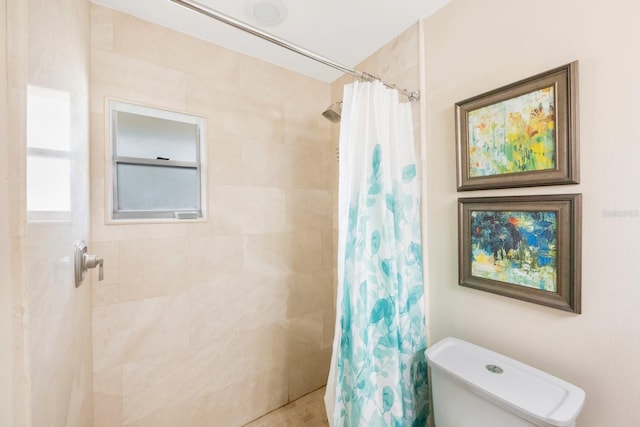 bathroom featuring a shower with curtain and toilet