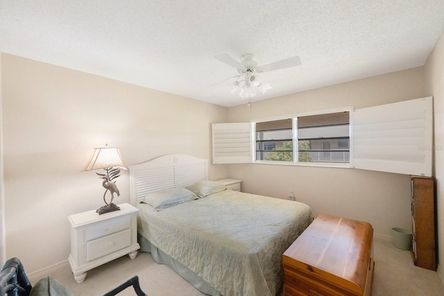 carpeted bedroom featuring ceiling fan and a textured ceiling